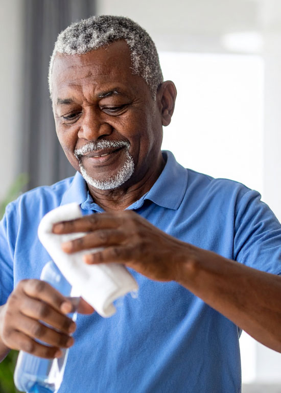 Homme nettoyant avec un chiffon dans une maison.