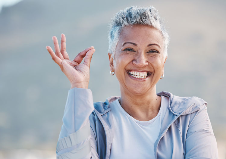 Femme souriante faisant le signe OK.