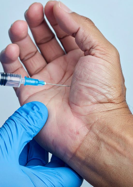 Injection dans la main avec une seringue.