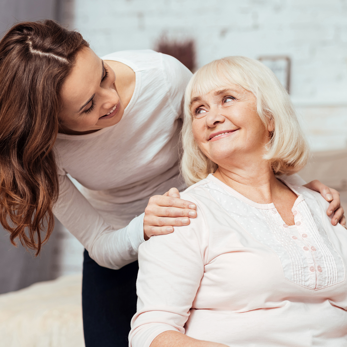 Femme souriante interagissant avec une senior bienveillante.