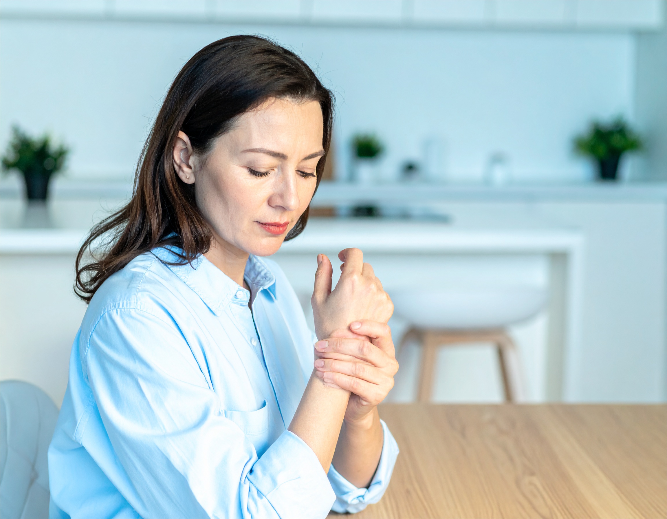 Femme se tenant le poignet, douleur apparente.