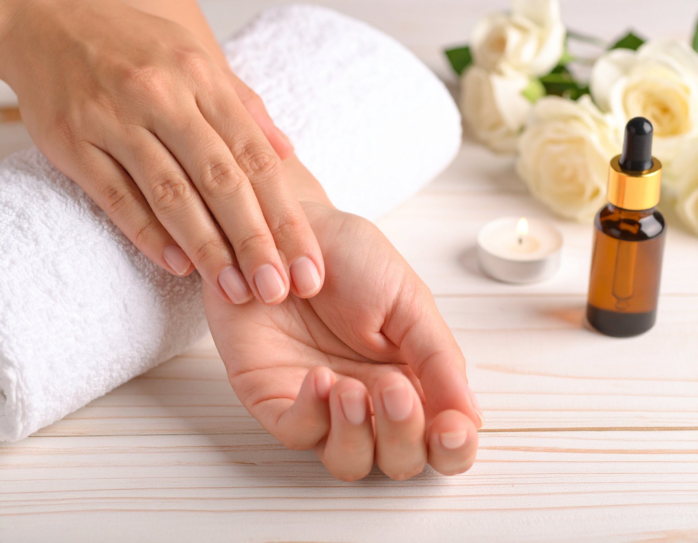 Soins des mains avec huile et bougie relaxante.