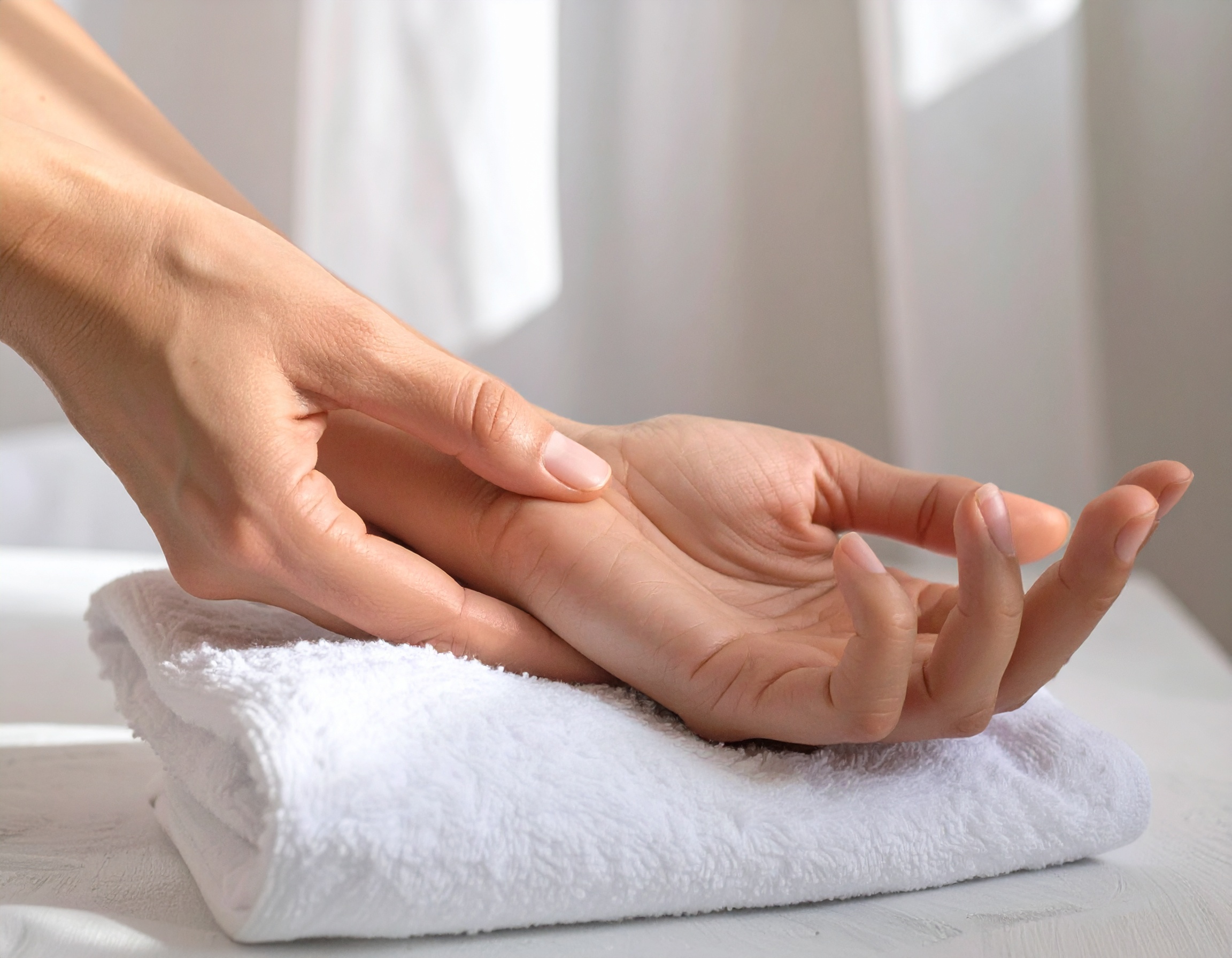 Main posée sur une serviette blanche