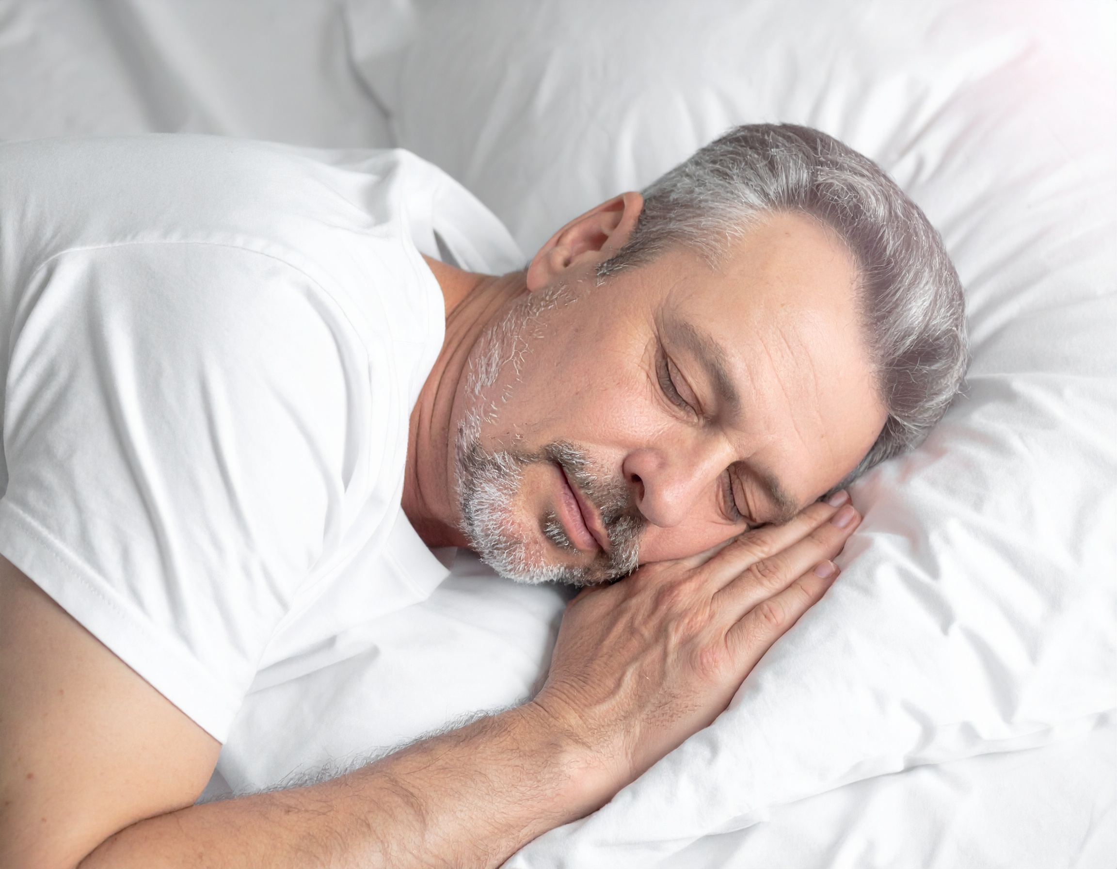 Homme âgé dormant paisiblement sur un oreiller