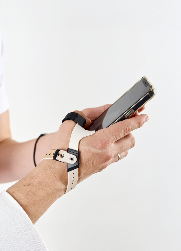 Hand met smartphone en ondersteunende polsband