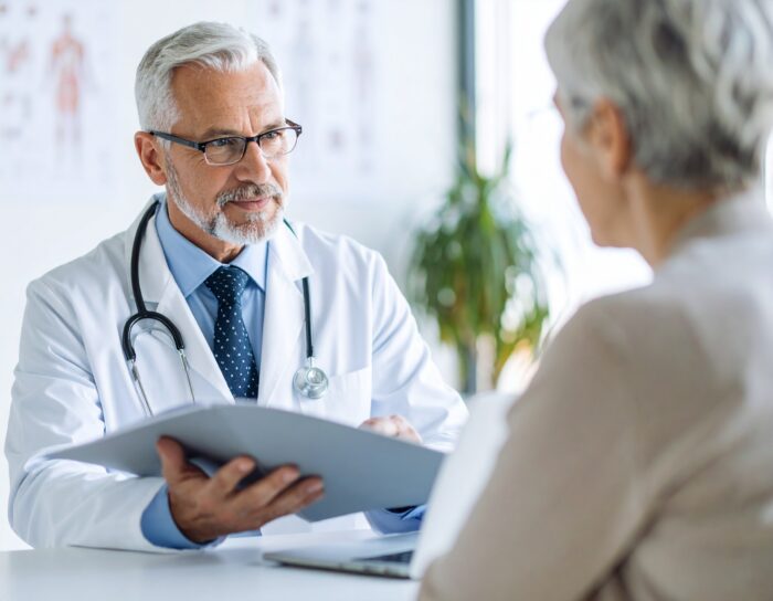 Dokter praat met een oudere patiënte.