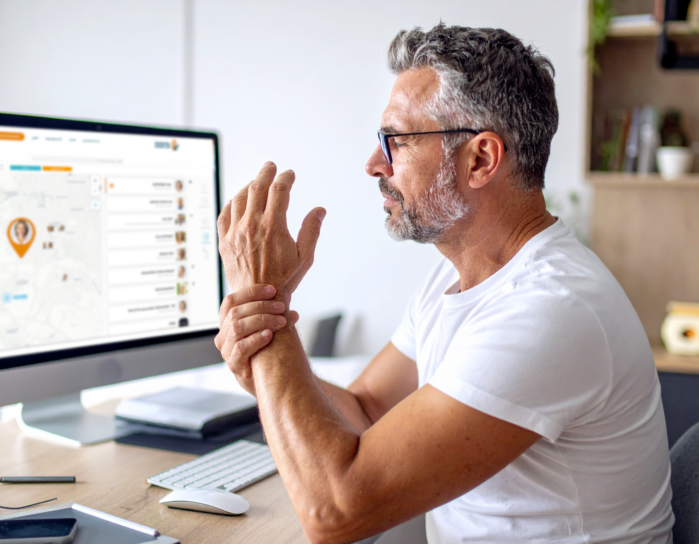 Man werkt achter computer in moderne kantooromgeving.